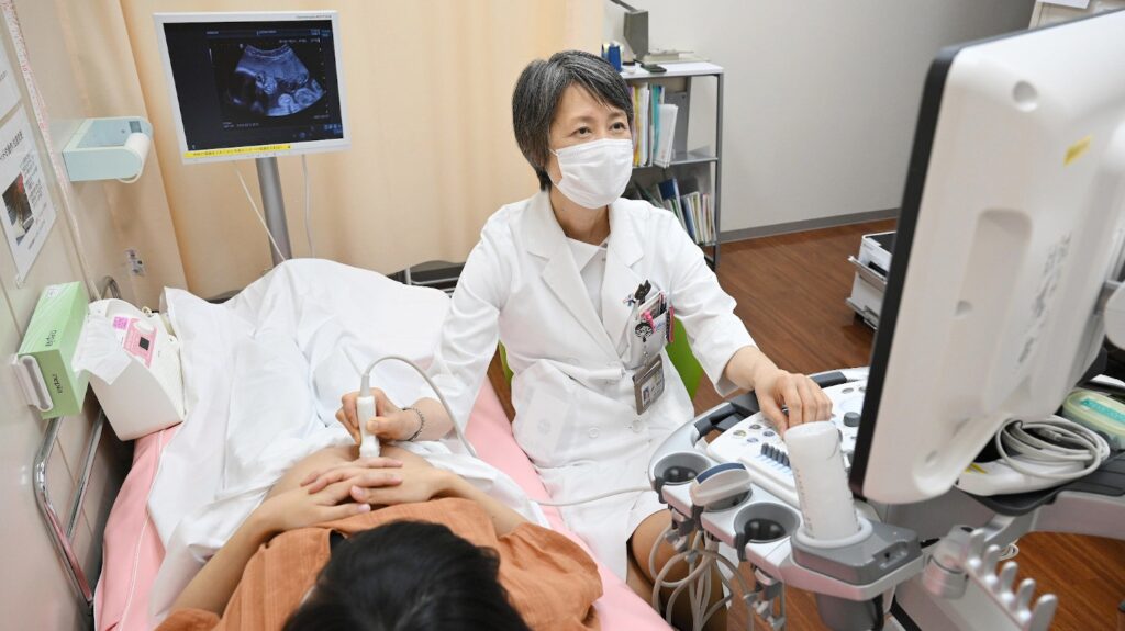 Foto de uma médica Japonesa atendendo um paciente em seu consultório no Japão